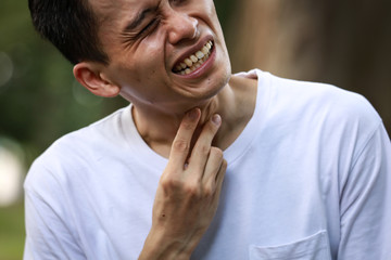 のどに痛みを感じる男性