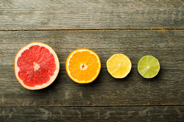Row of colorful citrus slices on a wooden background
