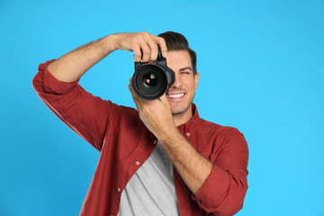 Professional photographer working on light blue background in studio