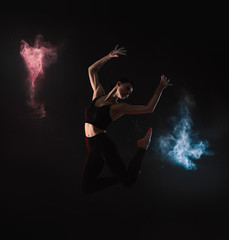 Professional acrobat with chalk powder exercising in dark studio