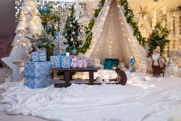 Christmas and New Year decorations with wigwam, fir tree, branches, bulbs, stars and warm garland lights. Winter, December holidays concept.