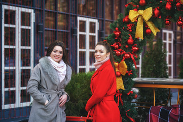 Young cheerful women on the street of Christmas city
