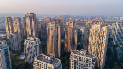 Fototapeta na wymiar Aerial drone shot over residential apartment buildings on sunset. Aerial shot over community apartment complex in China.