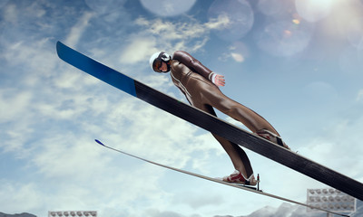 Skier in flight. Ski jumping on sunset.