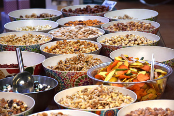 Handmade bowl with nuts surrounded by different organic foods in a Granada market