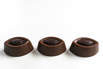 Three chocolates isolated on a white background. Copy space.
