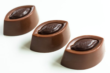Three chocolates isolated on a white background. Close-up.