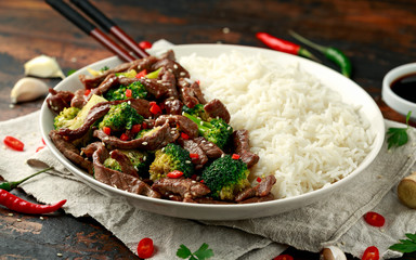 Homemade Beef and Broccoli with Rice and herbs on wooden table