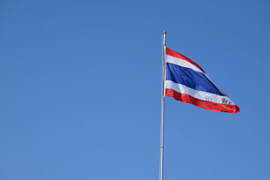 Thailand National Flag on the pole with blue sky.