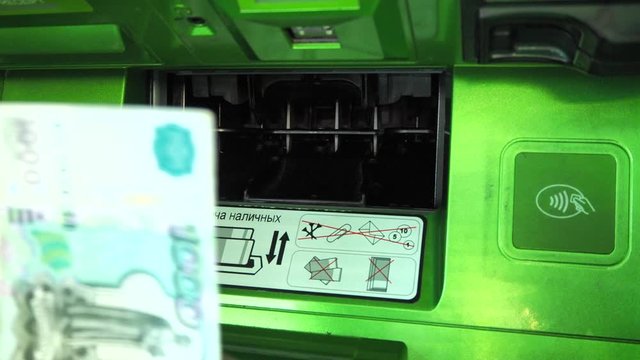 Close-up male hand takes money 1000 rubles from the ATM. Russian banknotes. The concept of getting a paycheck to repay a loan, pay utility bills and shop. Terminal for cash withdrawal.