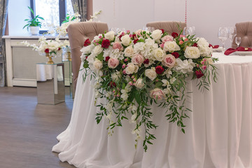 The table in the restaurant is decorated with a beautiful floral arrangement on the wedding day