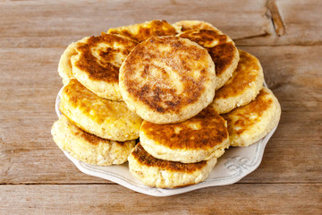 Obraz na płótnie Canvas Russian traditional syrniki cottage cheese pancakes breakfast on the plate on wooden background