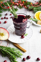 warming spiced wine in a glass with berries, spices and rosemary