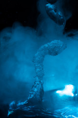 space geyser in blue fog and an asteroid on a black starry sky