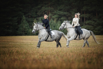 Two women riding horses.