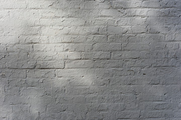 Surface of a white brick wall with sun glare