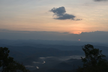 Morning clouds with the sunrise on foggy landscape