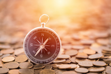 Financial concept with coins and compass © Jakub Krechowicz