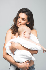 portrait of beautiful naked mom hugging baby, isolated on grey
