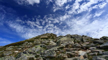 Clouds above a rocky hill
