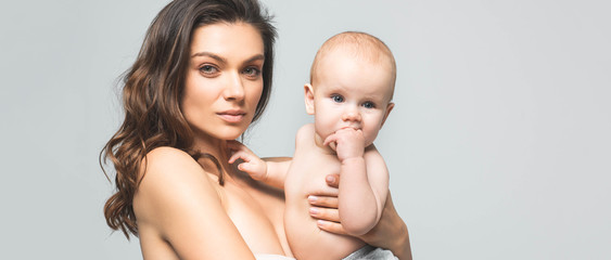 panoramic shot of attractive naked mother holding baby boy, isolated on grey