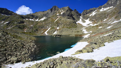 Naklejka na ściany i meble Snow sliding into mountain lake