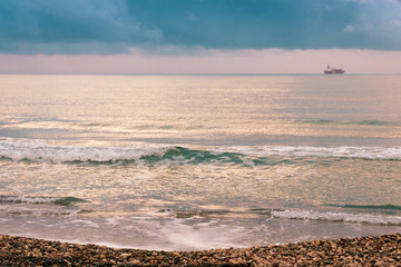 Calm sea waves against a dark and stormy sky