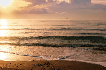 Calm sea waves in golden light in Larnaca