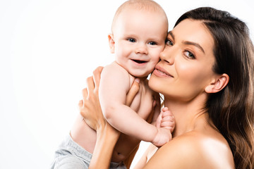 portrait of attractive nude mother holding cheerful baby, isolated on white