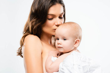 portrait of nude mother kissing cute baby, isolated on white