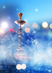 Hookah with smoke on a background of blurry lights. Abstract background, neon glow
