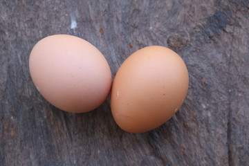 Two eggs set on a wooden table