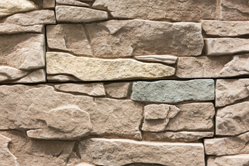 Light brown wall made of decorative stone. Beige stone for decoration. background