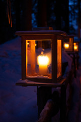 Caress Lake, South Tyrol, Italy. Lantern with warm orange light long path in the woods at night