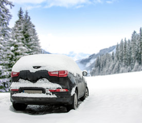 Winter black car cover of snow and winter landscape of forest and mountains. 