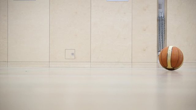 Basketball rolling in a gym