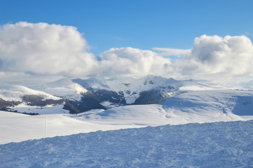 A beautiful viewpoint of the snowy volcanic mountain range during the winter, in Auvergne.