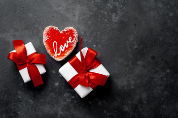 Two Cheesecake - a heart-shaped cake with the inscription love and a gift with a red ribbon for Valentines Day on a stone background with copy space for your text