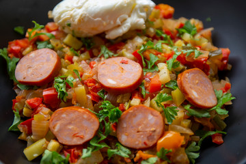 Spanish dish pisto manchego with chorizo sausages and poached egg