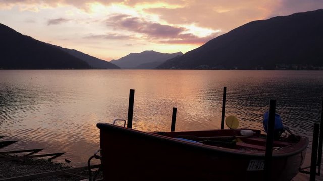 Lugano Lake. Boat at sunset in Bissone, tiny village on the lake.