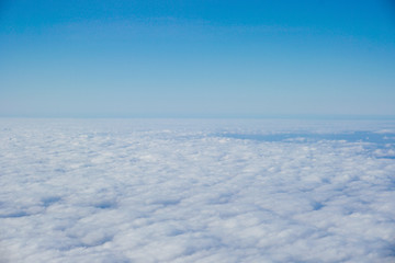 blue sky above white clouds from inside the plane