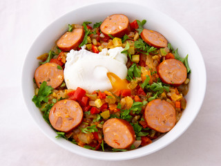 Spanish dish pisto manchego with chorizo sausages and poached egg