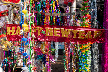 Fototapeta premium Jarmark noworoczny, Wielka wyprzedaż choinek i lalki Mikołaja. Sprzedaż sztucznych jodeł i świątecznych dekoracji w namiotach. Wesołych Świąt i Szczęśliwego Nowego Roku 2020.