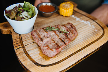 Juicy steak lies on a wooden Board