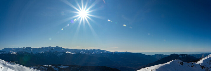 Rosa Khutor ski resort. Mountain landscape of Krasnaya Polyana and sun shining, Sochi, Russia.