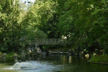 Fototapeta na wymiar Le pont rustique en rocaille sous la végétation très dense au parc Josaphat à Schaerbeek