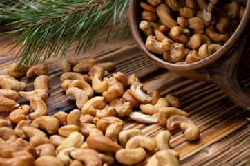 roasted cashew nuts on wooden boards close-up and ate in the background