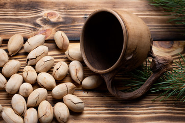 pecan next to a decorative cup and spruce on wooden boards close-up