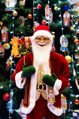 Merry Christmas and Happy new Year , Santa Claus doll with lamp in Christmas festival , Copy space. Cute grandfather frost in red costume and green gloves on tree background. gift and celebration.