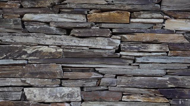 Stone wall made of multi-colored layered natural sandstone